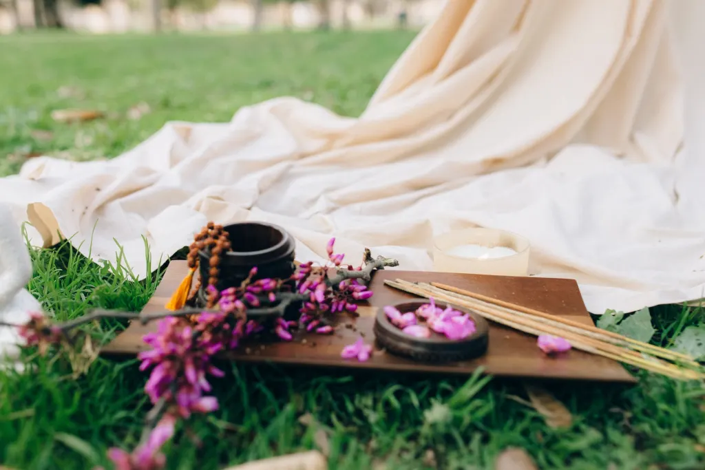 blanket with incense and flower petals on lawn